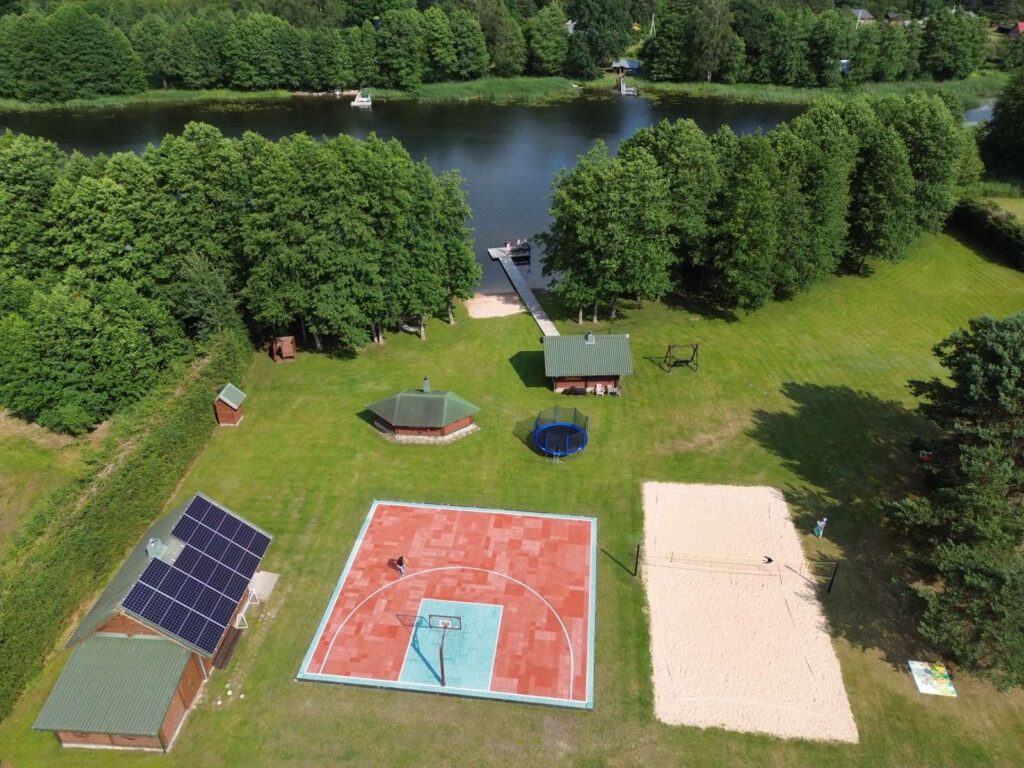 Vaikai žaidžia tinklinį stovyklos metu